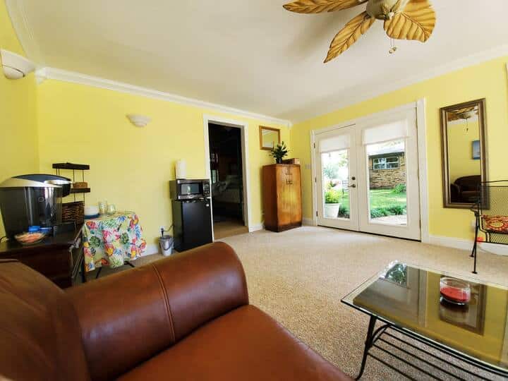 Outside the double french doors you can see the landscaped yard and sitting area under the tree, main house beyond that. The doors do have shades for your privacy.  Cabana was freshly painted and new carpet in the living area. 